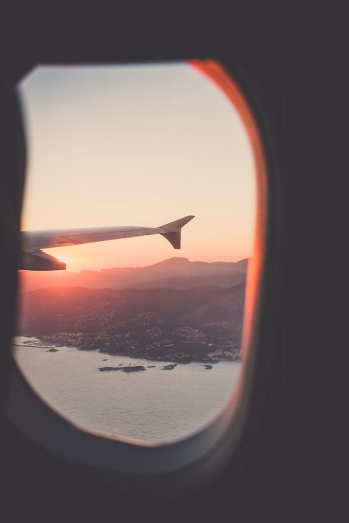 a window with a view of a sunset and water below