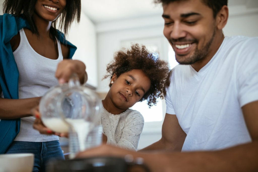 family of three pouring milk